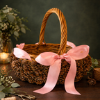 Pinecone basket with pink ribbon handmade by Ausable wreath company on a table as a table decor surrounded by leaves