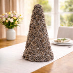 Ausable wreath company Decorative cone made of pinecones on a table with a blurred background